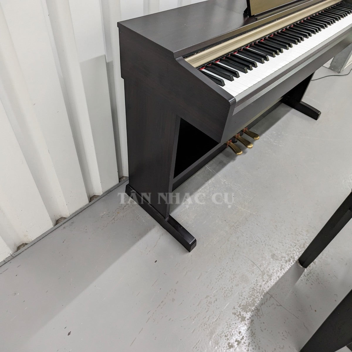 Đàn piano điện Yamaha YDP-151 dáng tủ màu gỗ nâu tại TÂN NHẠC CỤ, thiết kế chắc chắn với 3 pedal.