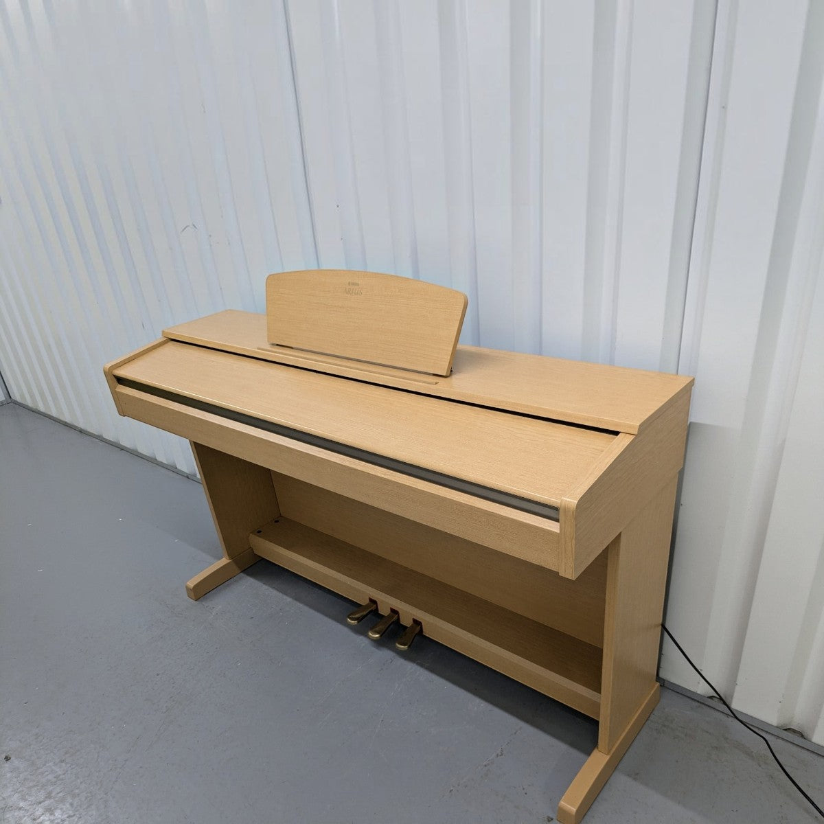 Đàn piano điện Yamaha YDP161 màu gỗ sáng tại TÂN NHẠC CỤ với thiết kế dáng tủ sang trọng và 3 pedal chắc chắn.