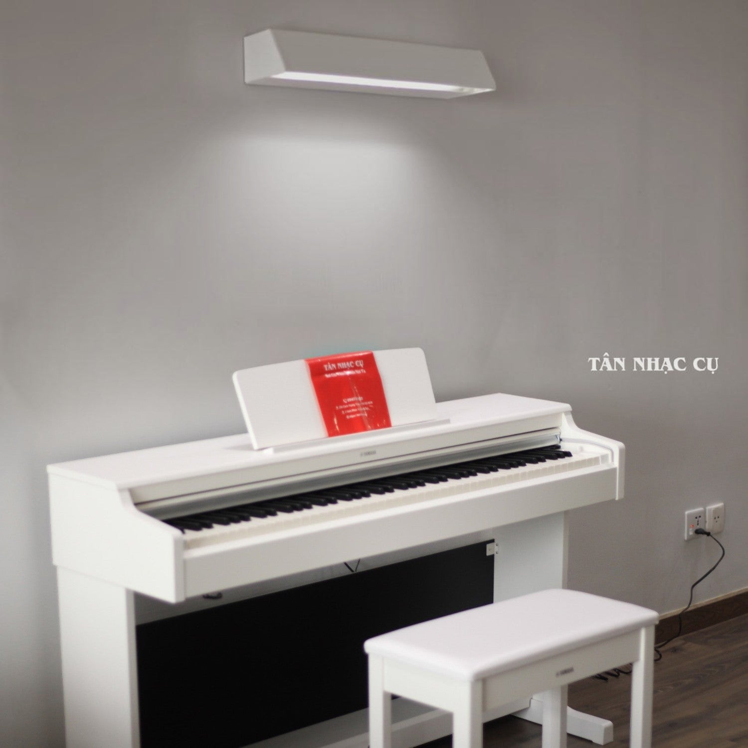 Đàn piano điện Yamaha YDP-165 màu trắng sang trọng tại Tân Nhạc Cụ, thiết kế dáng tủ đứng kèm ghế ngồi đồng bộ.