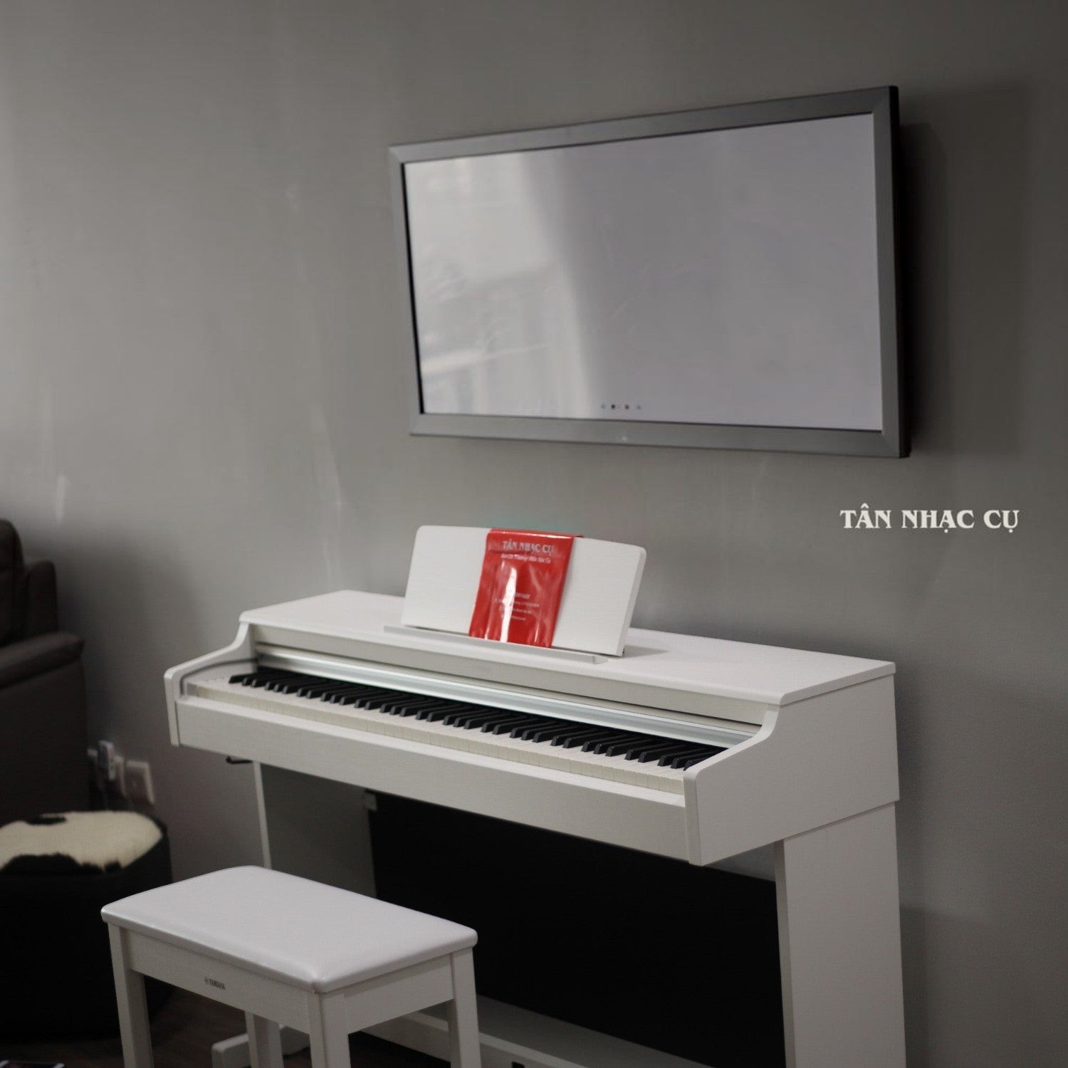 Đàn piano điện Yamaha YDP-165 màu trắng tại TÂN NHẠC CỤ, thiết kế dáng tủ đứng hiện đại kèm ghế ngồi đồng bộ.