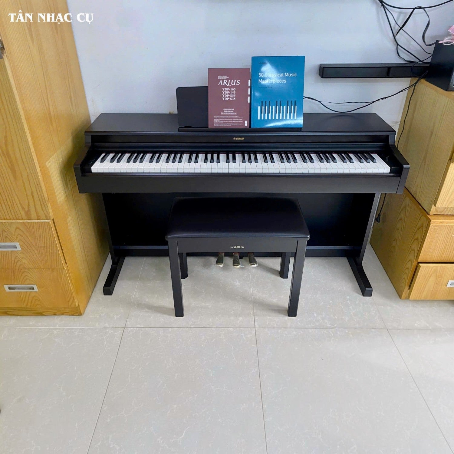 Đàn piano điện Yamaha YDP-165 màu đen tại TÂN NHẠC CỤ, dáng tủ đứng kèm ghế và sách nhạc