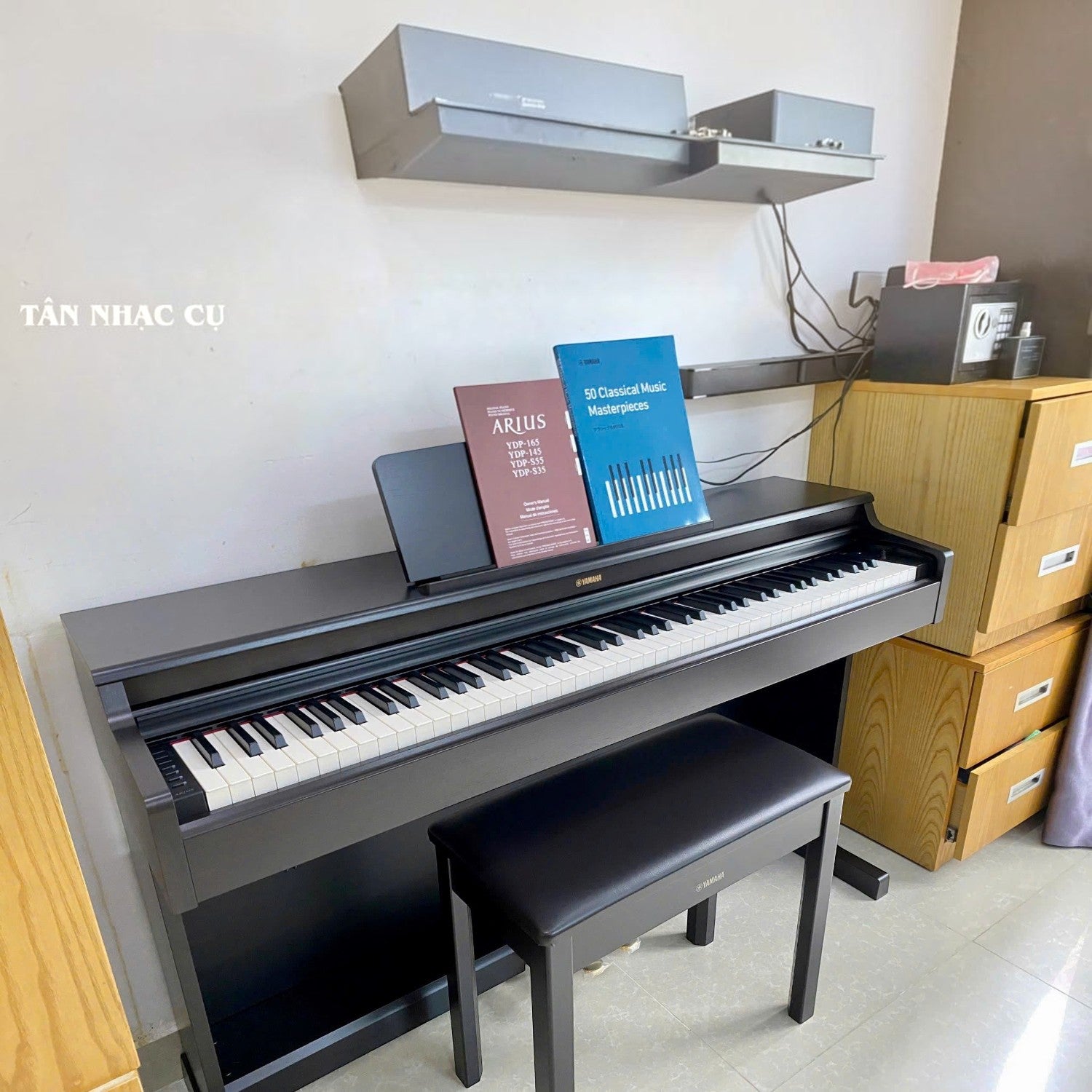 Đàn piano điện Yamaha YDP-165 màu đen dáng tủ đứng tại Tân Nhạc Cụ, kèm ghế và sách nhạc