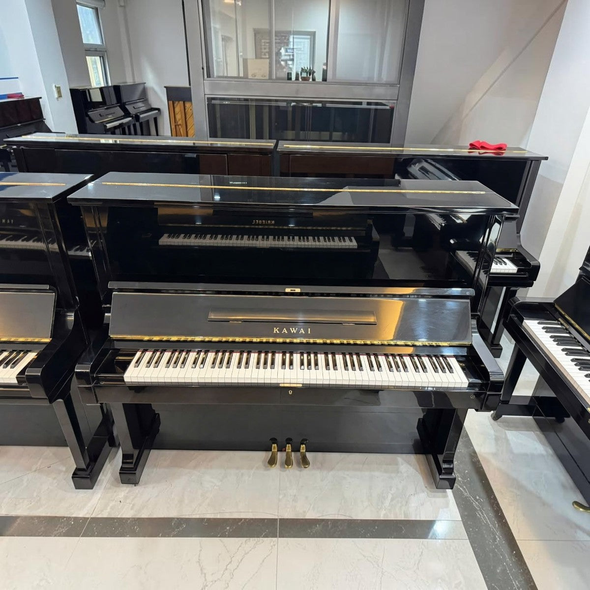 Đàn piano cơ upright Kawai KS3 màu đen bóng sang trọng tại TÂN NHẠC CỤ, thiết kế cổ điển với 3 pedal chắc chắn.
