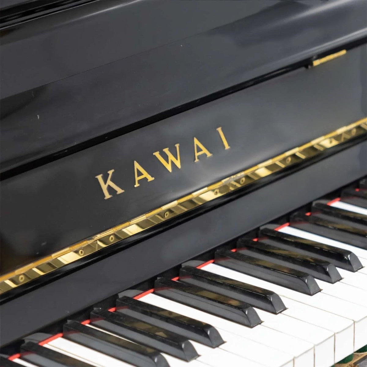 Đàn piano cơ Kawai KS5F màu đen bóng sang trọng tại TÂN NHẠC CỤ với logo vàng nổi bật trên nắp phím