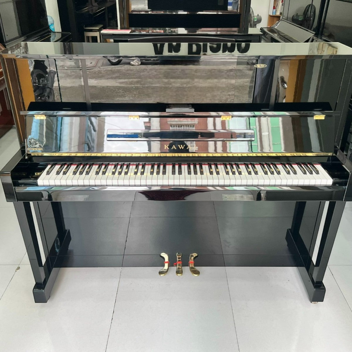 Đàn piano cơ upright Kawai KU10 màu đen bóng sang trọng tại TÂN NHẠC CỤ, thiết kế cổ điển với 3 pedal vàng sáng bóng