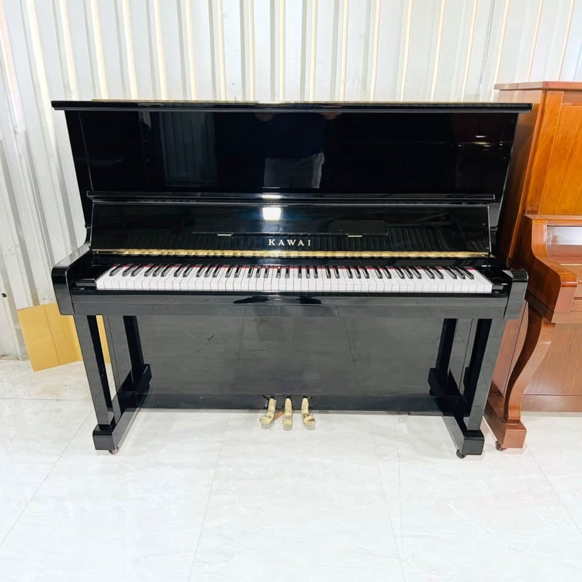 Đàn piano cơ Kawai KU1D màu đen bóng sang trọng tại TÂN NHẠC CỤ, thiết kế upright cổ điển với 88 phím đàn.