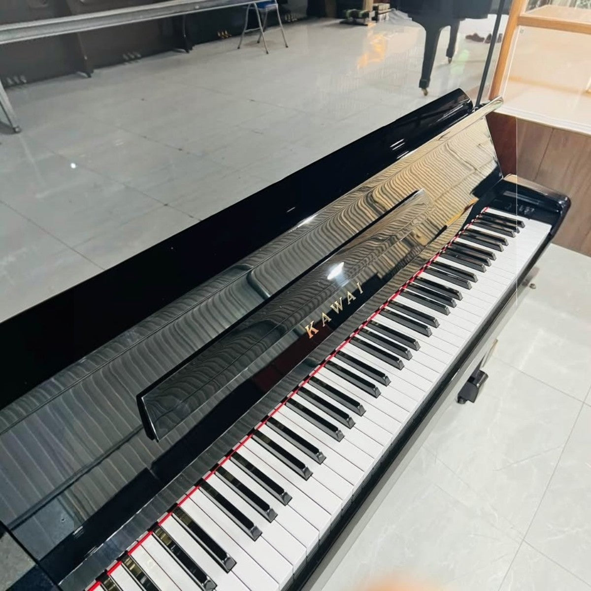 Đàn piano cơ Kawai KU1D màu đen bóng sang trọng tại TÂN NHẠC CỤ, thiết kế upright cổ điển với 88 phím đàn.