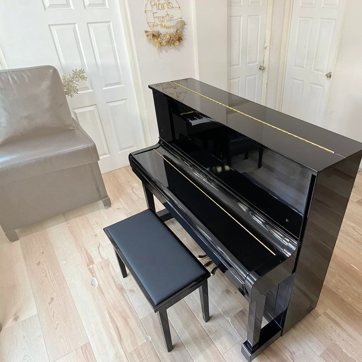 Đàn piano cơ Kawai KU1D màu đen bóng sang trọng tại TÂN NHẠC CỤ, thiết kế upright cổ điển với ghế ngồi đồng bộ.