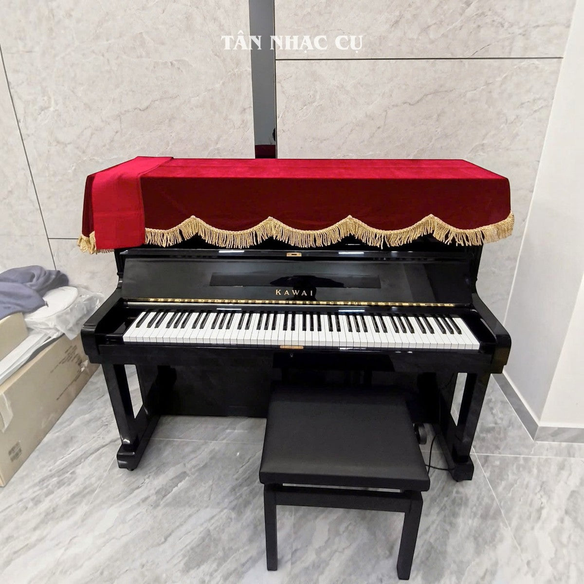 Đàn piano cơ upright Kawai KU2D màu đen bóng sang trọng với khăn phủ đỏ tại cửa hàng TÂN NHẠC CỤ