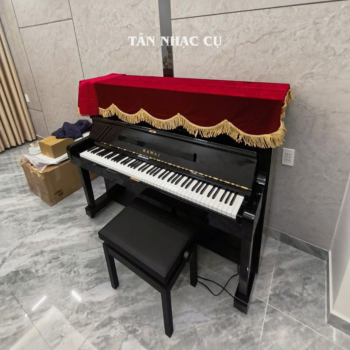Đàn piano cơ upright Kawai KU2D màu đen bóng sang trọng tại TÂN NHẠC CỤ, có khăn phủ đỏ trang trí