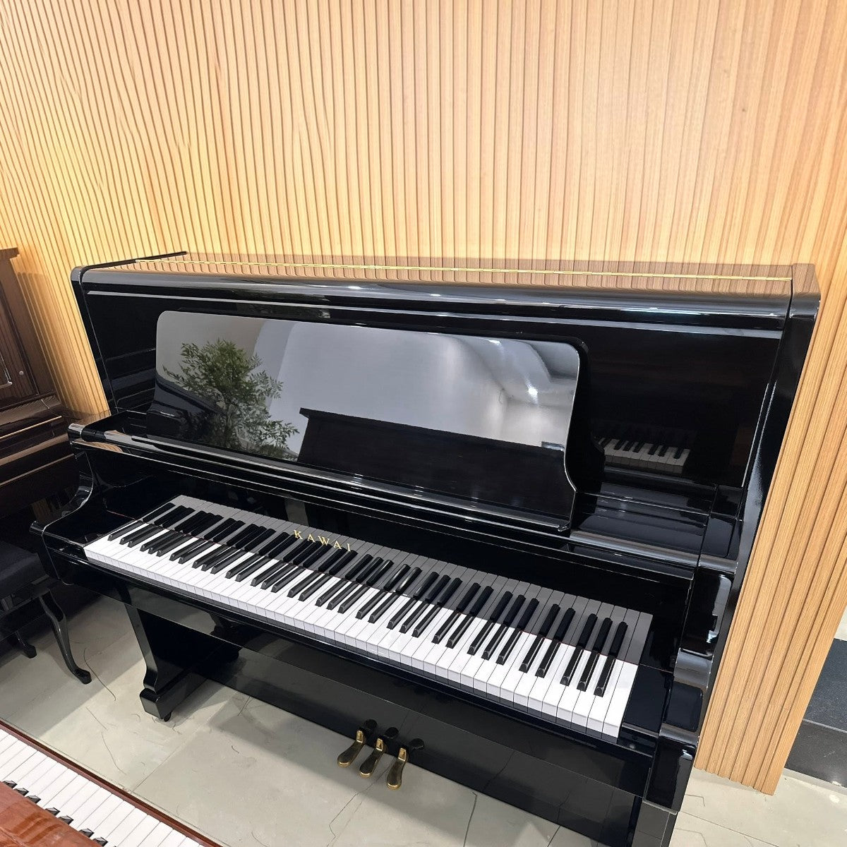 Đàn piano cơ upright Kawai US50 màu đen bóng sang trọng tại Tân Nhạc Cụ với thiết kế cao cấp và phím đàn tinh tế