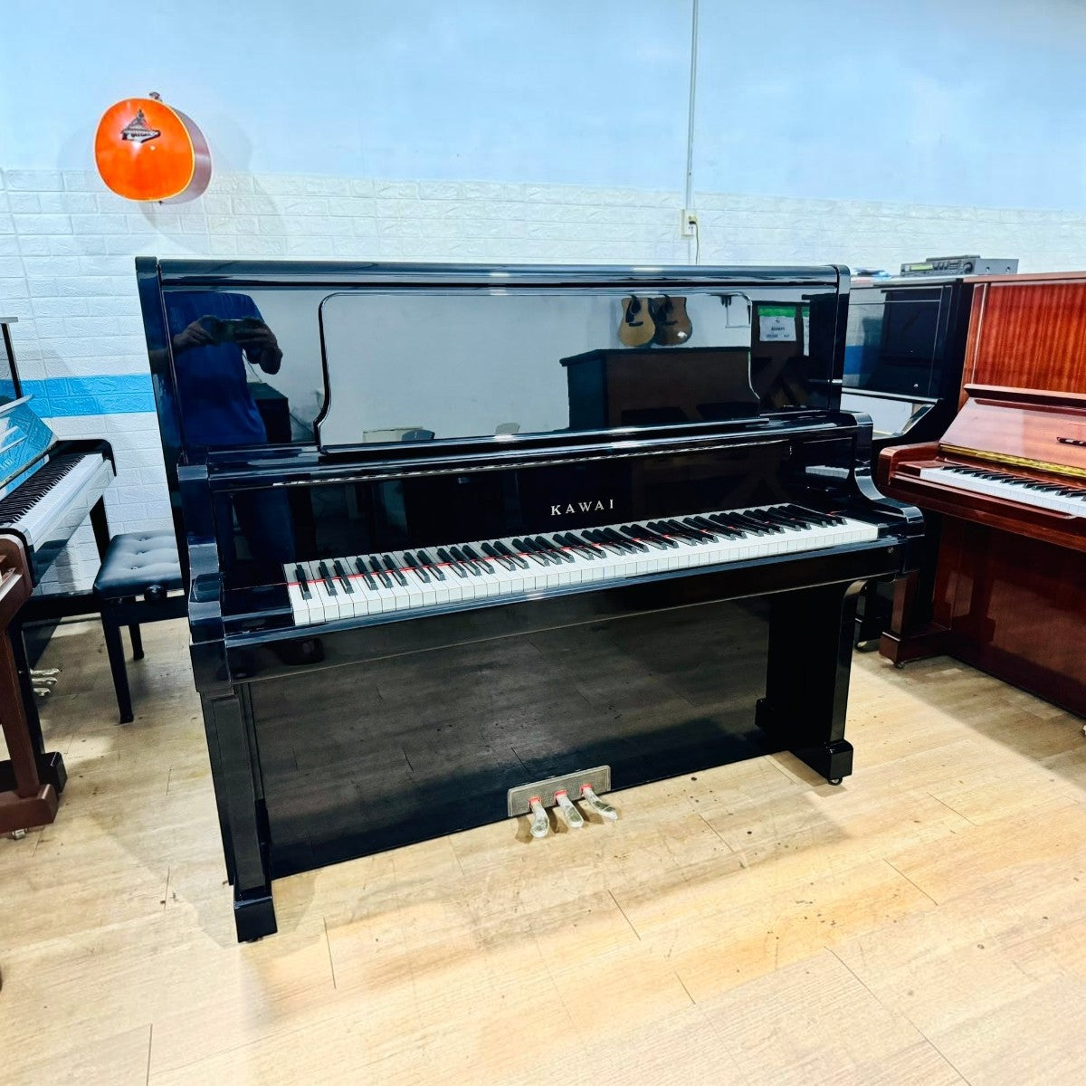 Đàn piano cơ upright Kawai US7X màu đen bóng sang trọng tại Tân Nhạc Cụ, thiết kế đỉnh cao với mặt phím ngà nhân tạo.