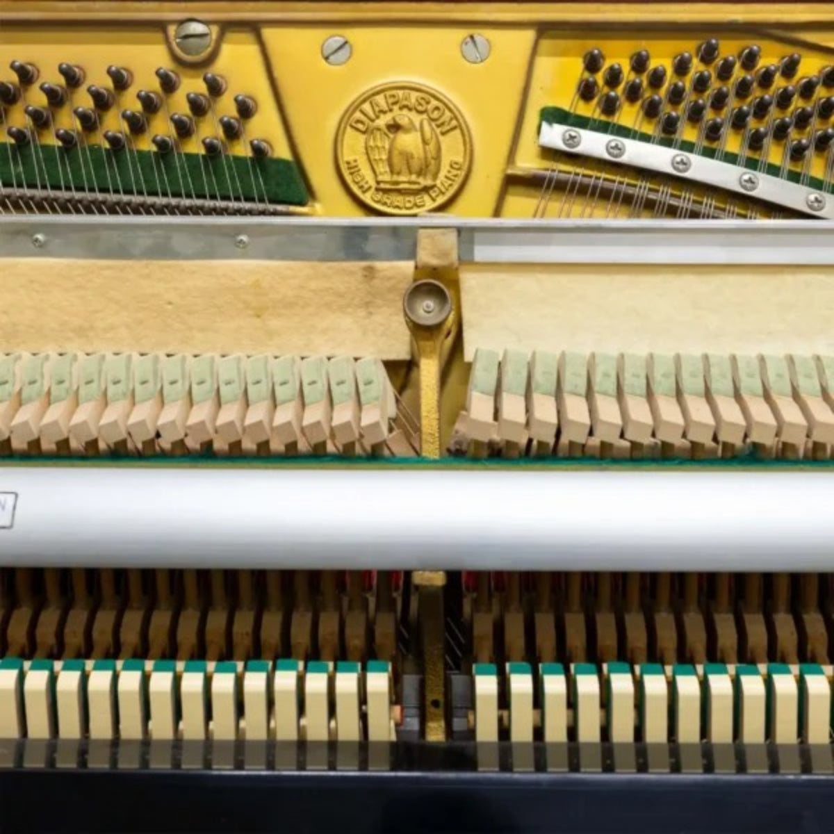 Chi tiết bộ máy và khung gang đàn piano cơ TÂN NHẠC CỤ Diapason 125M1 với logo thương hiệu nổi bật