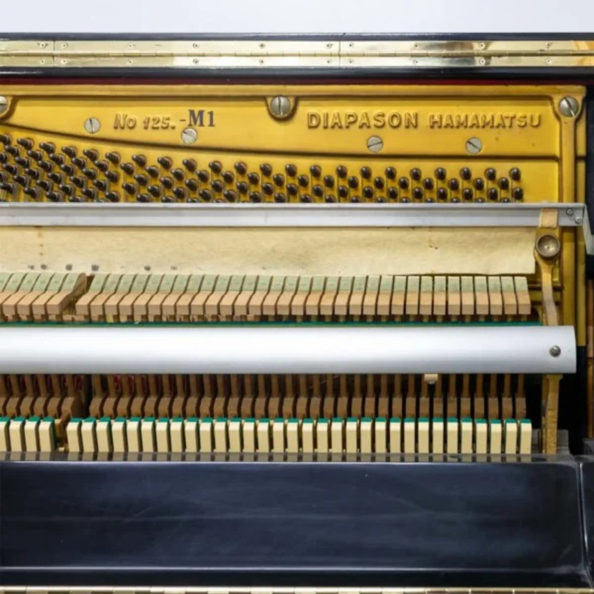 Chi tiết khung gang và bộ máy bên trong đàn piano cơ TÂN NHẠC CỤ Diapason 125M1 với các chốt lên dây và búa đàn