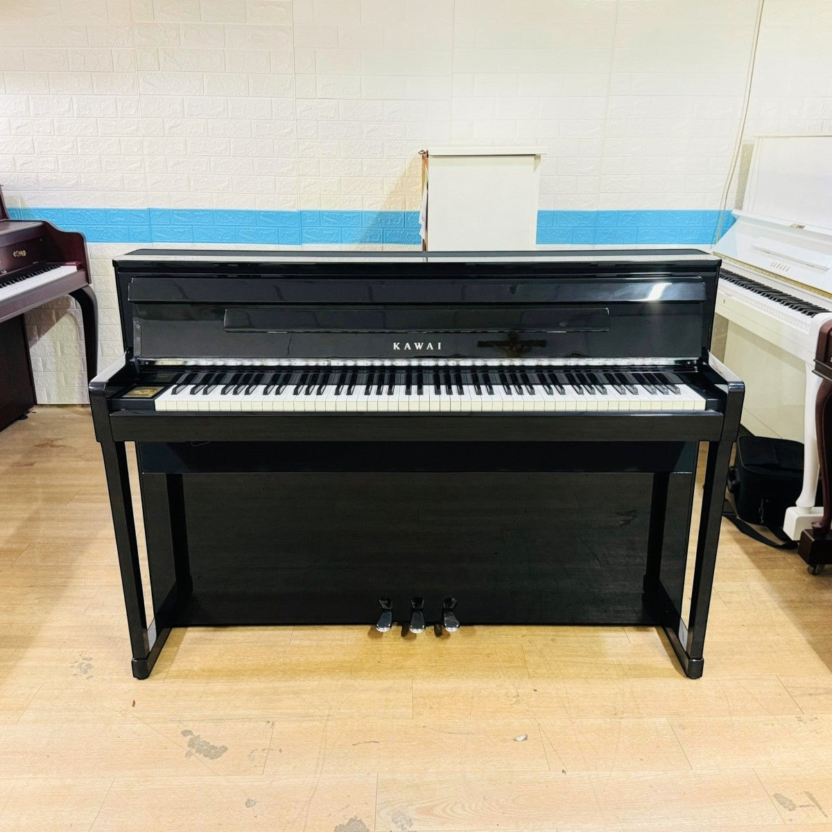 Đàn piano điện TÂN NHẠC CỤ Kawai CA99 màu đen bóng sang trọng với thiết kế upright hiện đại và bàn phím gỗ thật
