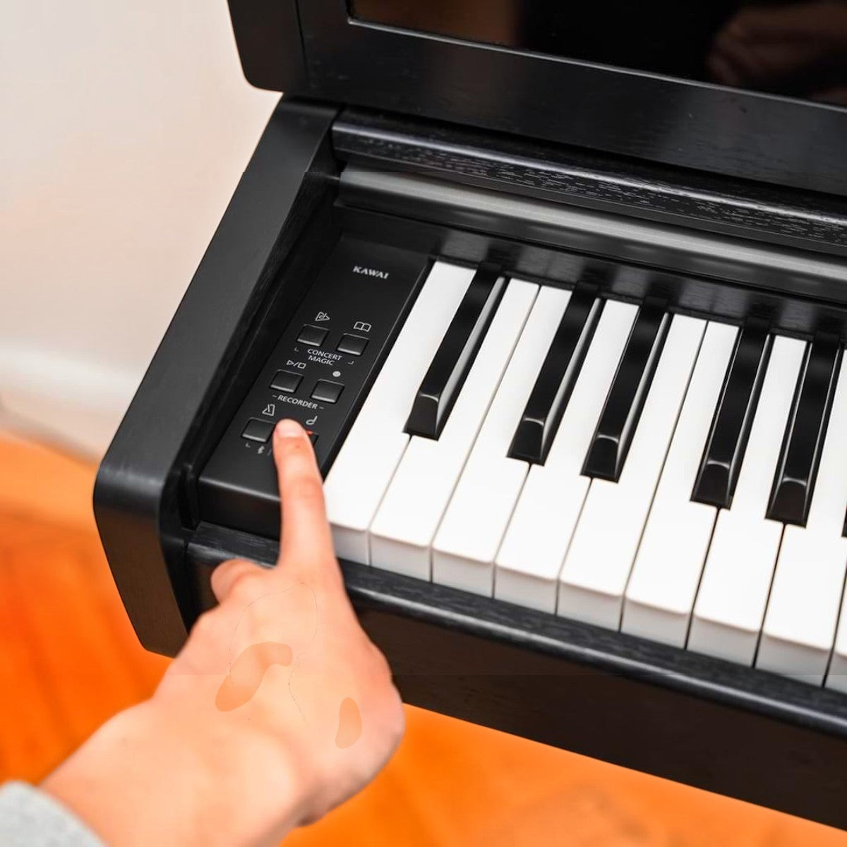 Bàn phím đàn piano điện Kawai CX202 màu đen với bảng điều khiển bên trái, ngón tay đang nhấn nút tại Tân Nhạc Cụ