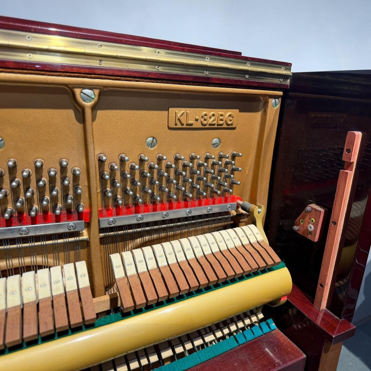 Chi tiết khung gang và bộ máy bên trong đàn piano cơ Kawai KL32BG tại Tân Nhạc Cụ với màu gỗ đỏ sang trọng