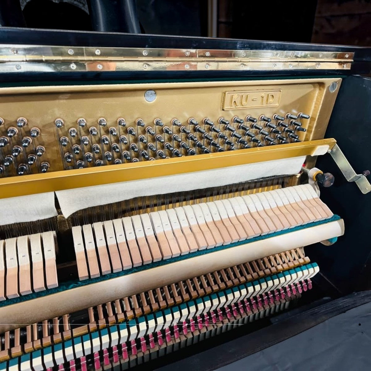 Bên trong đàn piano cơ TÂN NHẠC CỤ Kawai KU1D với khung gang vàng, búa đàn và hệ thống dây kim loại chi tiết