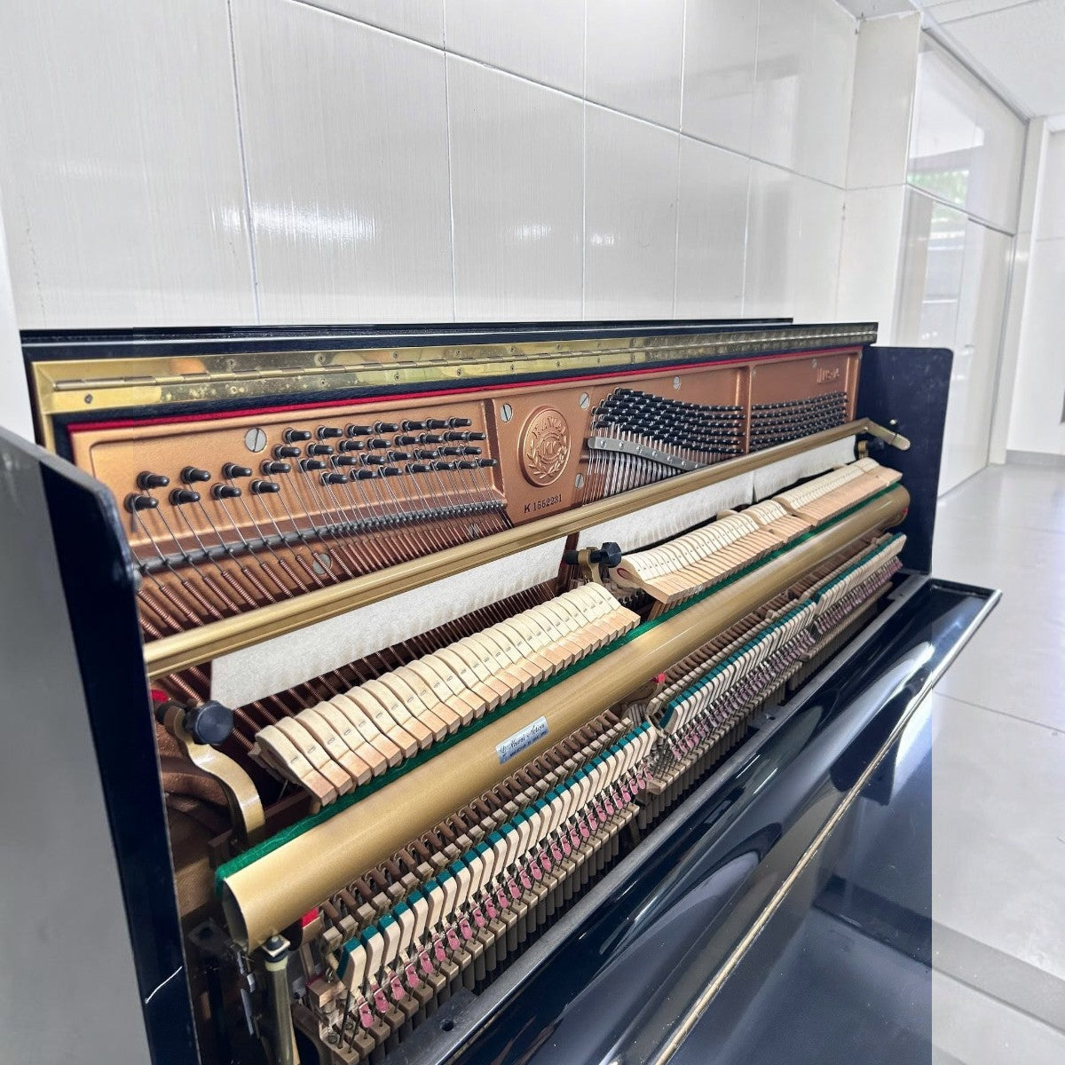Bộ máy cơ bên trong đàn piano Kawai NS15 màu đen bóng tại TÂN NHẠC CỤ với các búa đàn và dây kim loại chi tiết
