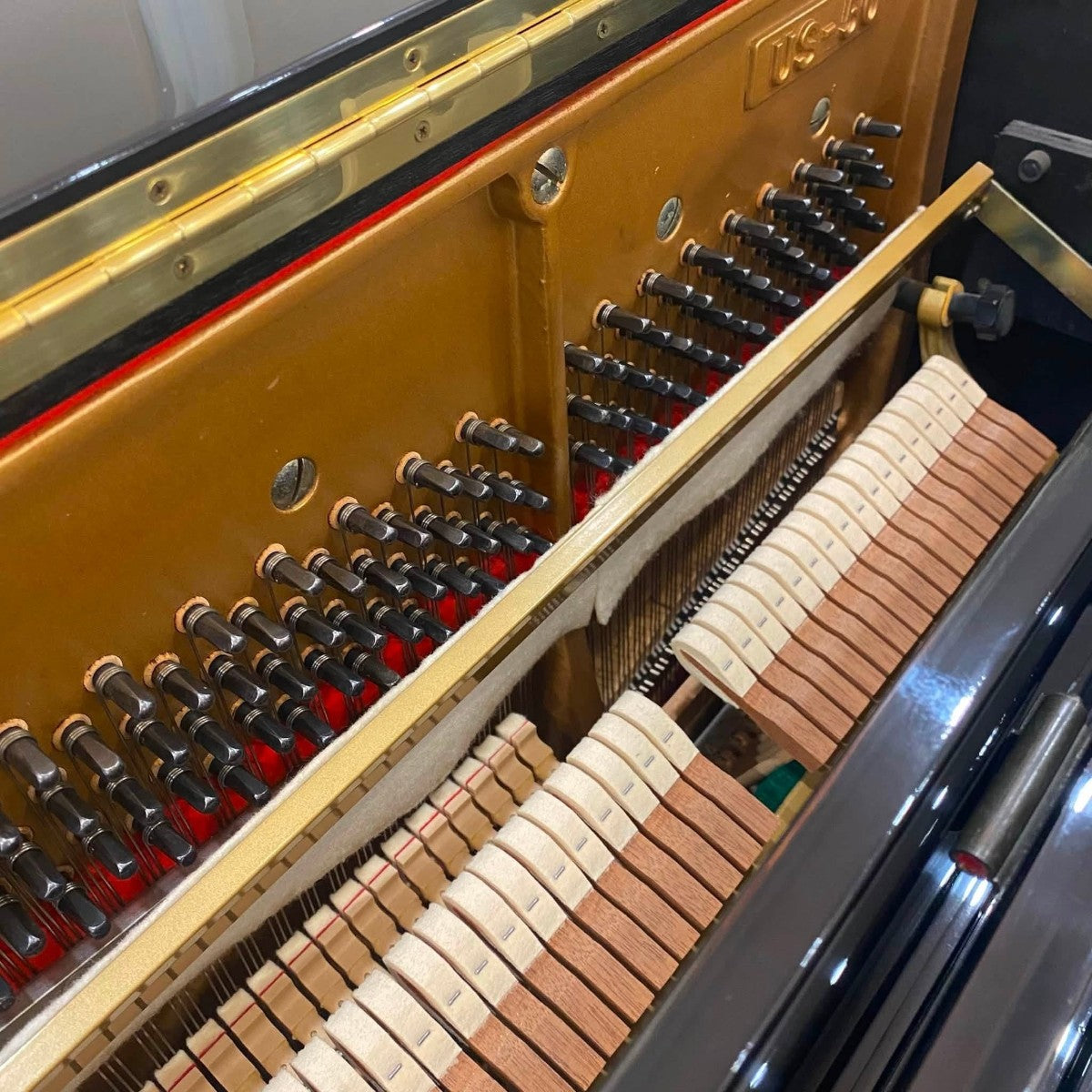 Bộ máy đàn piano cơ Kawai US50 tại Tân Nhạc Cụ với các chi tiết búa đàn và chốt lên dây kim loại sáng bóng