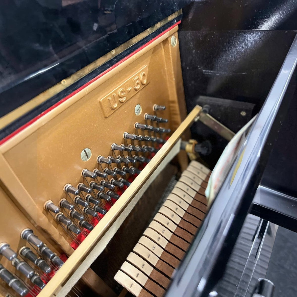 Khung gang và bộ máy bên trong đàn piano cơ TÂN NHẠC CỤ Kawai US50 màu đen bóng với các chốt lên dây kim loại