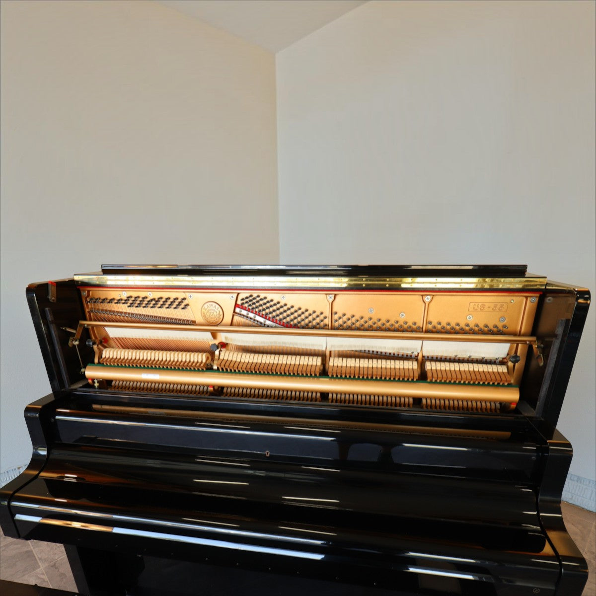 Đàn piano cơ Kawai US55 màu đen bóng tại TÂN NHẠC CỤ với nắp trên mở lộ khung gang và bộ máy bên trong