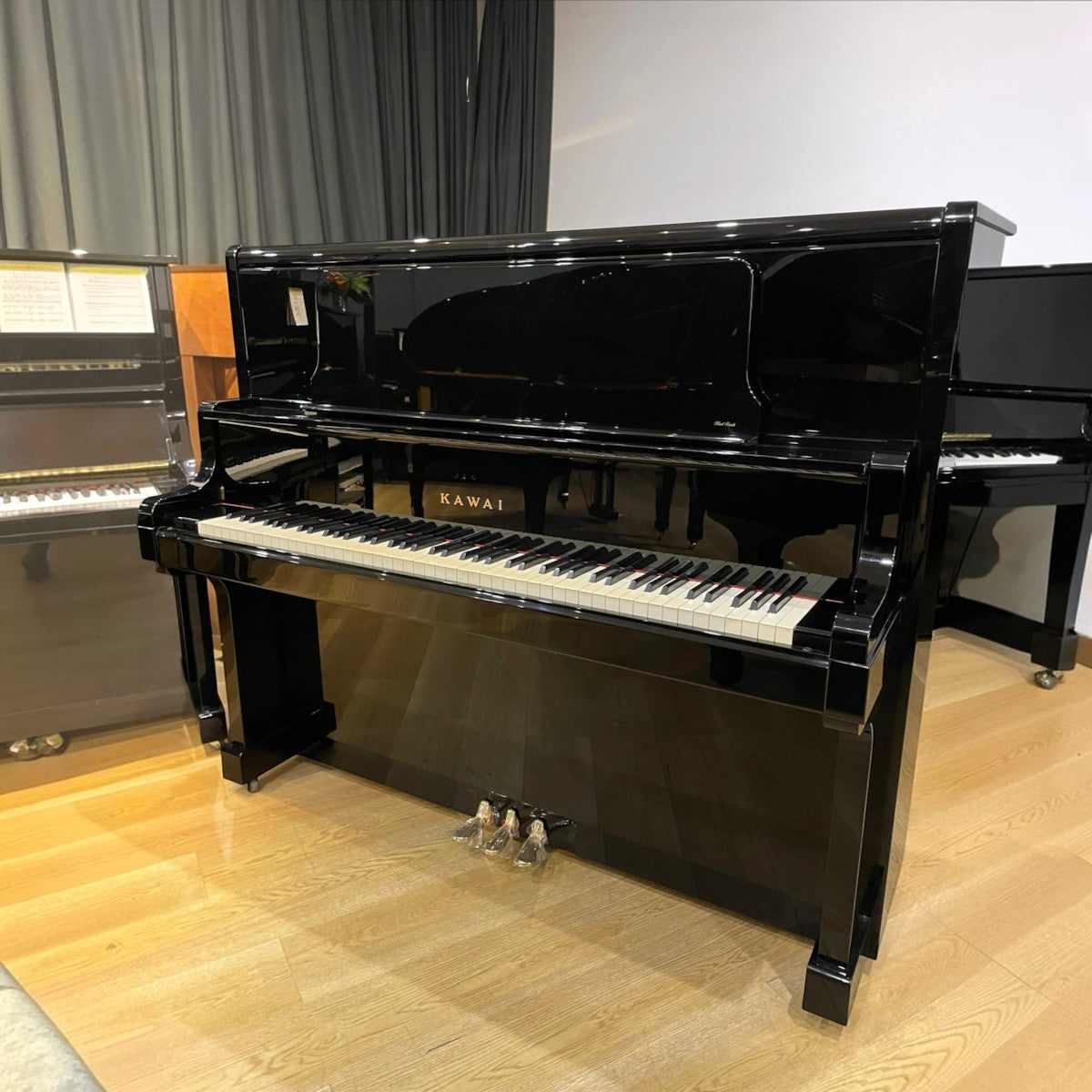 Đàn piano cơ Kawai US55 màu đen bóng sang trọng tại Tân Nhạc Cụ, dòng concert upright cao cấp với thiết kế tinh tế.