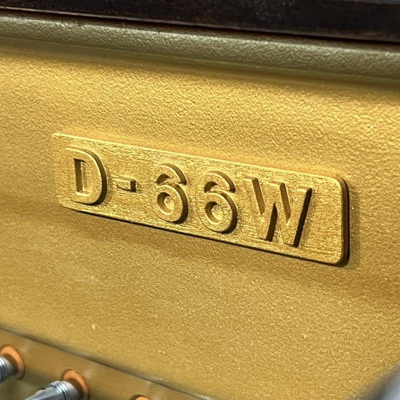 Logo model D66W bằng đồng nổi bật trên khung gang vàng của đàn piano cơ TÂN NHẠC CỤ