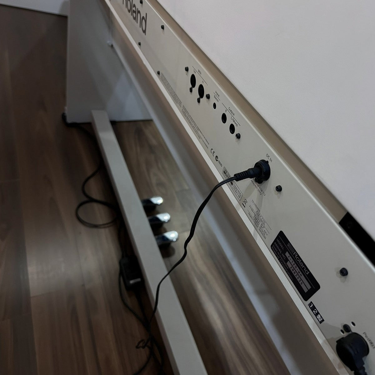 Mặt sau đàn piano điện Roland F120 màu trắng tại Tân Nhạc Cụ với các cổng kết nối và dây nguồn