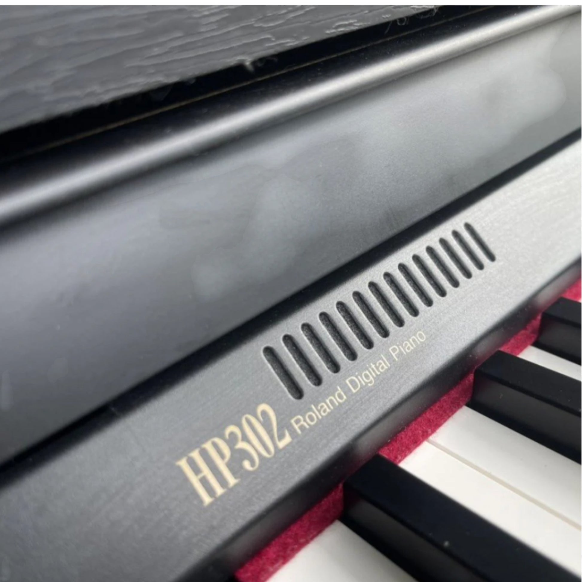 Cận cảnh bảng điều khiển và logo Roland HP302 trên đàn piano điện tại TÂN NHẠC CỤ