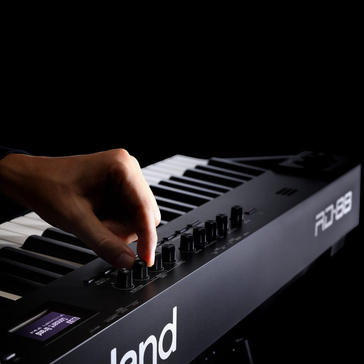 Tay người đang điều chỉnh núm vặn trên đàn piano điện TÂN NHẠC CỤ Roland RD-88 màu đen chuyên nghiệp