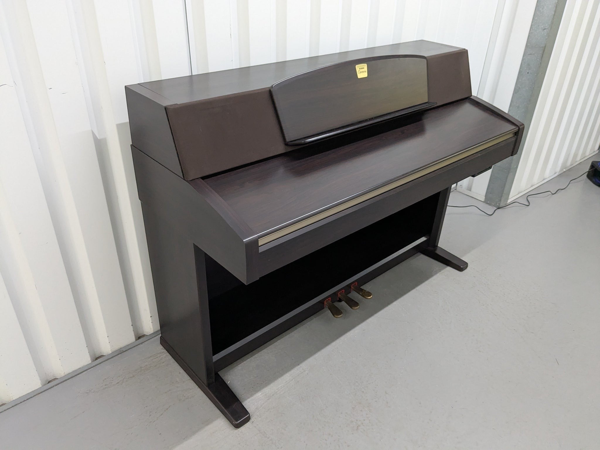 Đàn piano điện Yamaha CLP-970 màu nâu gỗ sang trọng tại TÂN NHẠC CỤ, thiết kế dáng tủ cổ điển với 3 pedal.