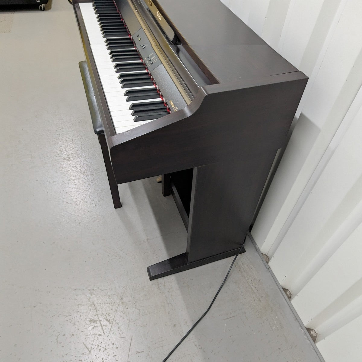 Đàn piano điện TÂN NHẠC CỤ Yamaha CLP930 dáng tủ màu gỗ tối với bàn phím búa GH, góc nhìn nghiêng từ trên xuống.