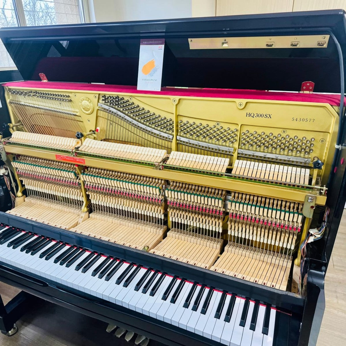 Đàn piano cơ Yamaha HQ300SX tại TÂN NHẠC CỤ, màu đen bóng, lộ bộ máy cơ bên trong với khung gang V-Pro và búa đàn gỗ.