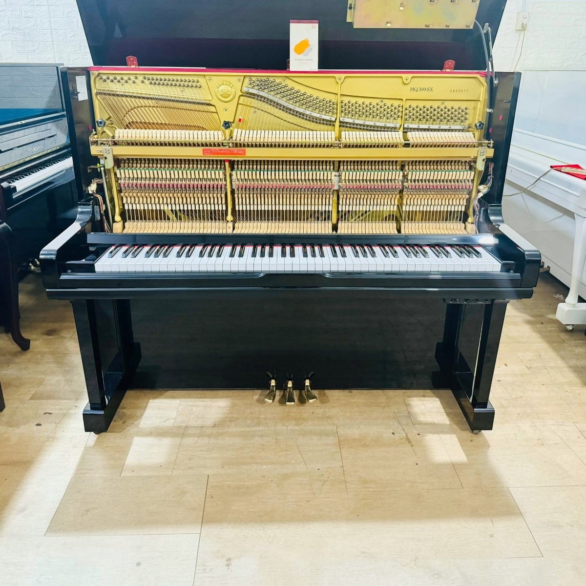 Đàn piano cơ TÂN NHẠC CỤ Yamaha HQ300SX màu đen bóng, thiết kế upright 131cm với hệ tự chơi và Silent tích hợp.