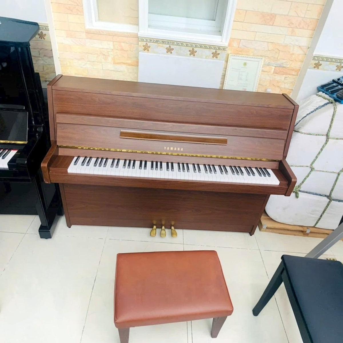 Đàn piano cơ TÂN NHẠC CỤ Yamaha MC101 vân gỗ Mahogany sang trọng, dáng console gọn nhẹ, màu nâu ấm áp.