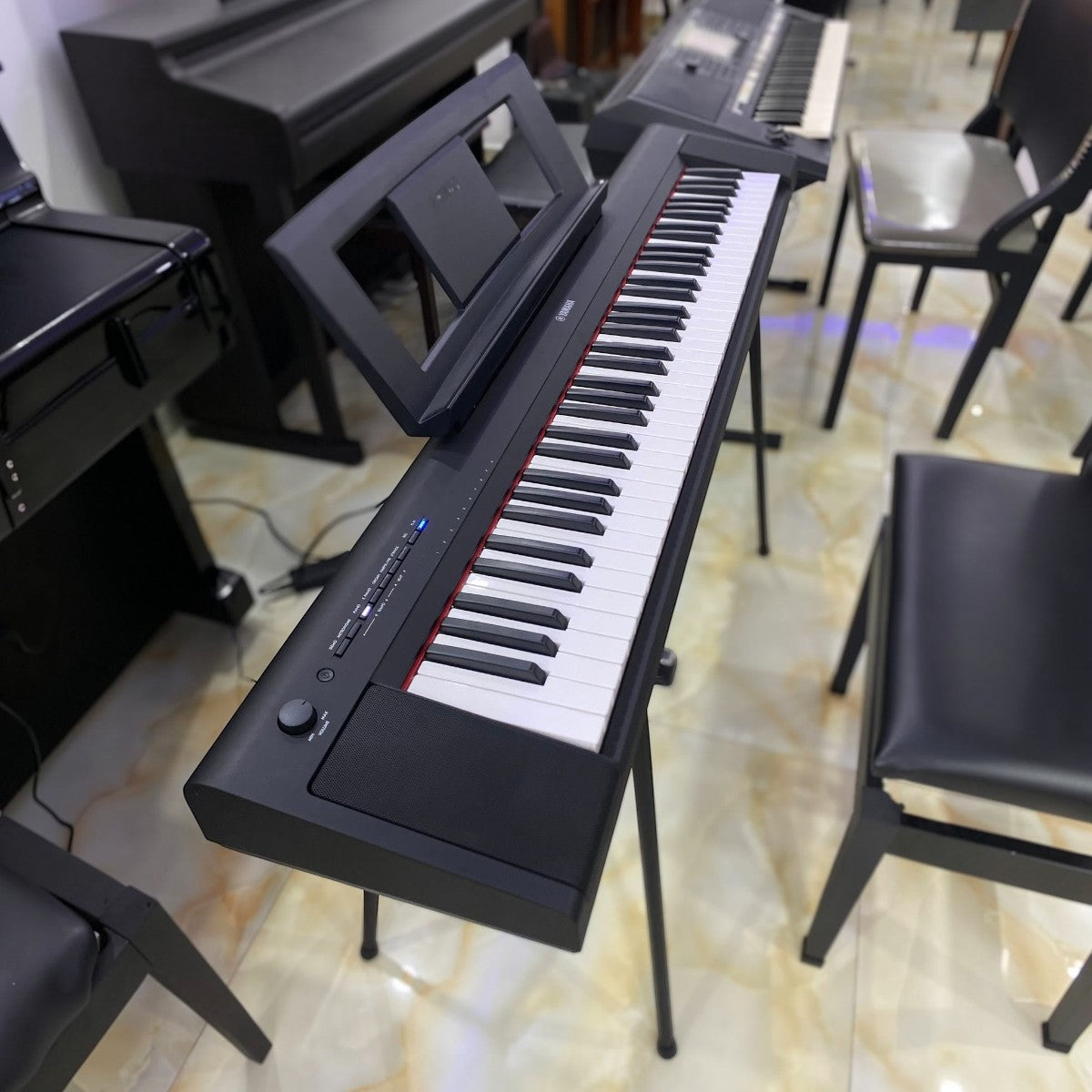 Đàn piano điện TÂN NHẠC CỤ Yamaha NP35 màu đen, thiết kế 76 phím gọn nhẹ, đặt trên chân đàn tại showroom