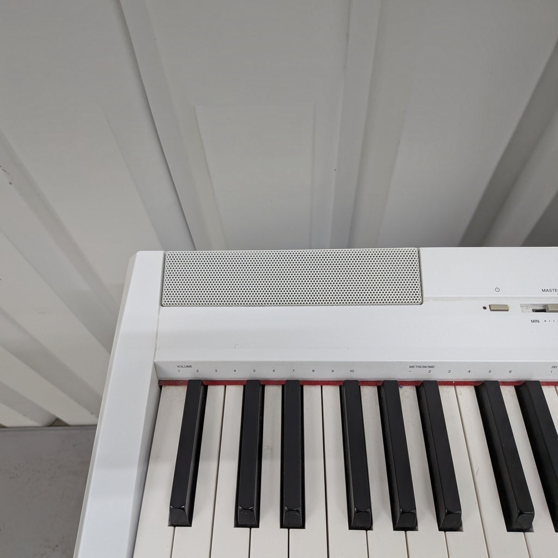 Đàn piano điện Yamaha P-115 màu trắng tại TÂN NHẠC CỤ, góc nhìn cận cảnh bàn phím GHS và loa tích hợp.
