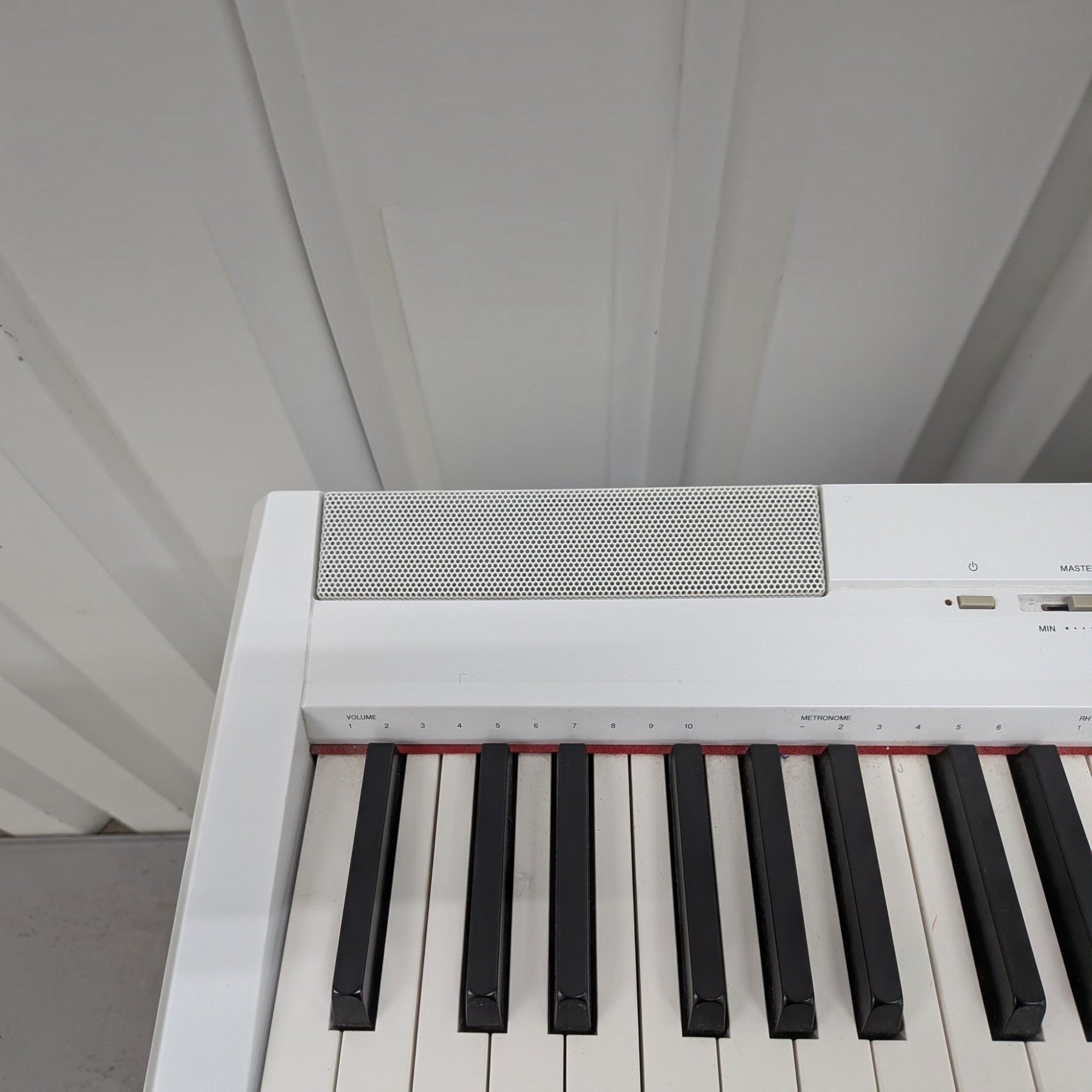 Đàn piano điện Yamaha P-115 màu trắng tại TÂN NHẠC CỤ, góc nhìn cận cảnh bàn phím GHS và loa tích hợp.
