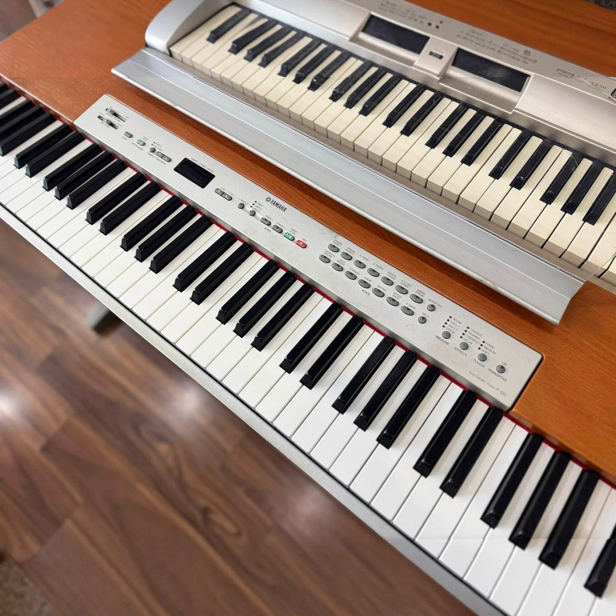 Đàn piano điện TÂN NHẠC CỤ Yamaha P120S màu bạc với bàn phím 88 phím búa GH đặt trên mặt bàn gỗ