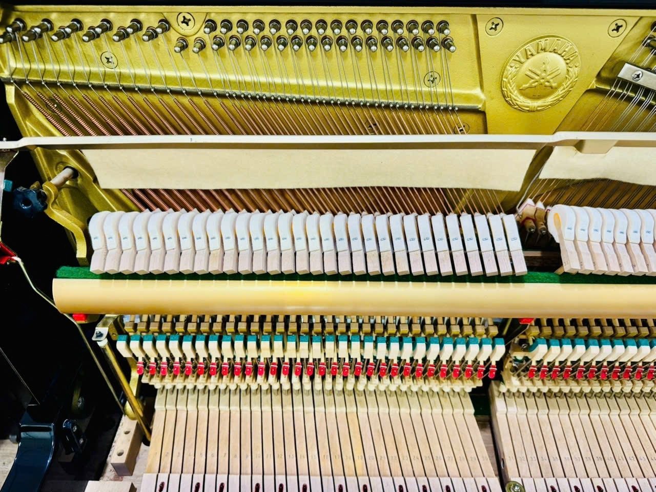 Bộ máy đàn piano cơ Yamaha U100 tại TÂN NHẠC CỤ với khung gang vàng, búa đàn lông cừu và dây đàn sáng bóng